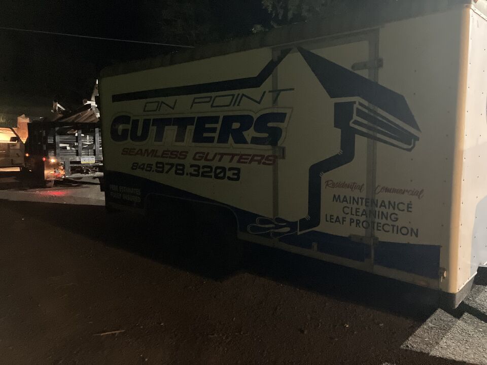 The On Point Gutters trailer on a job site