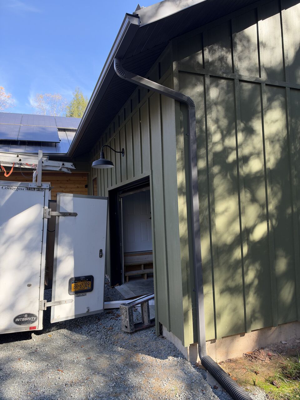 Long seamless gutter run along a green board-and-batten elevation
